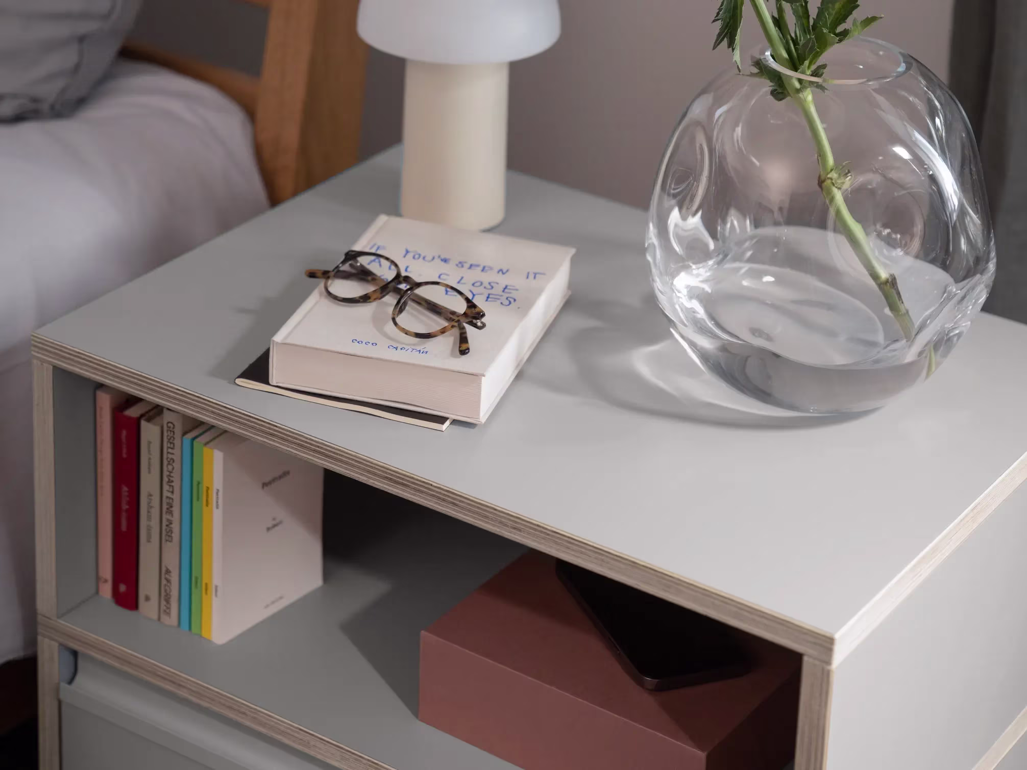 A bedside table in a furnished room
